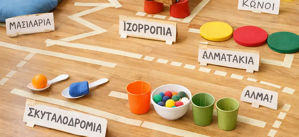 Διάφορα υλικά, όπως μπαλάκια, κώνοι, χαρτοταινία, μαξιλάρια κ.τ.λ. που φτιάχνουν μια διαδρομή για ισορροπία και σκυταλοδρομία